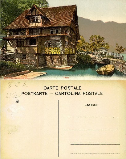 Lakeside building with boats and mountains