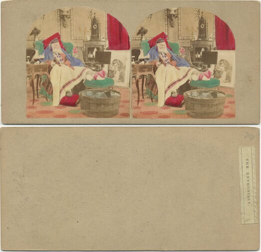Man in armchair with red cap and beard