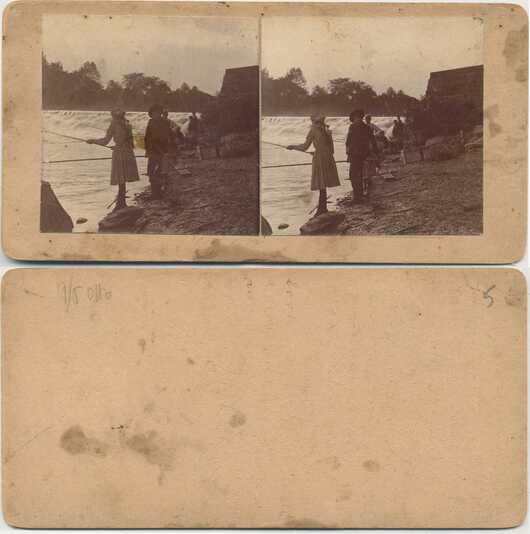 People Fishing Below a Dam